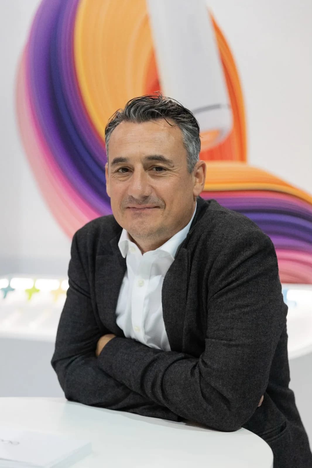 Rob Harvey, arms folded at a stand table